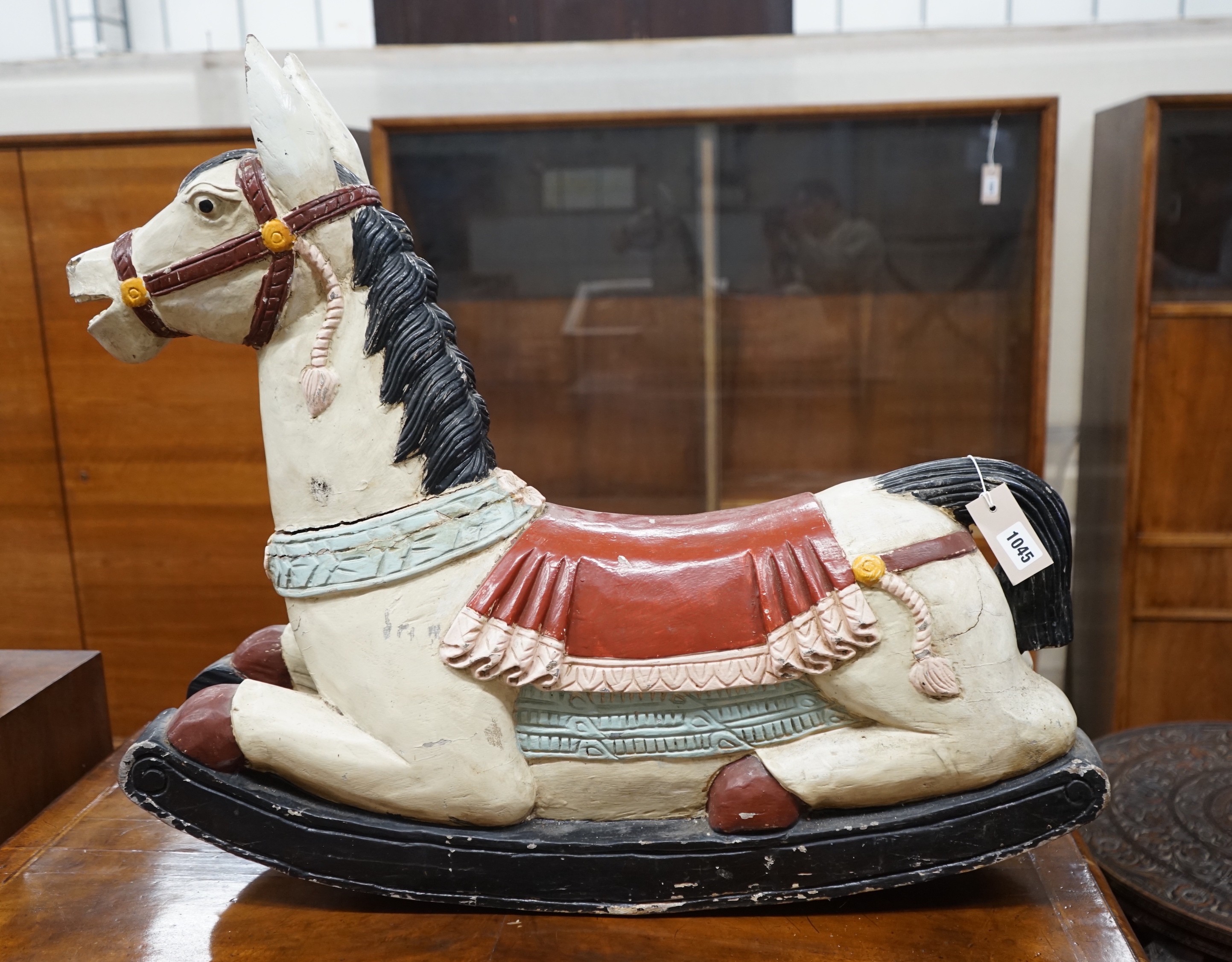 An Indonesian painted carved wood rocking horse, length 75cm, height 66cm